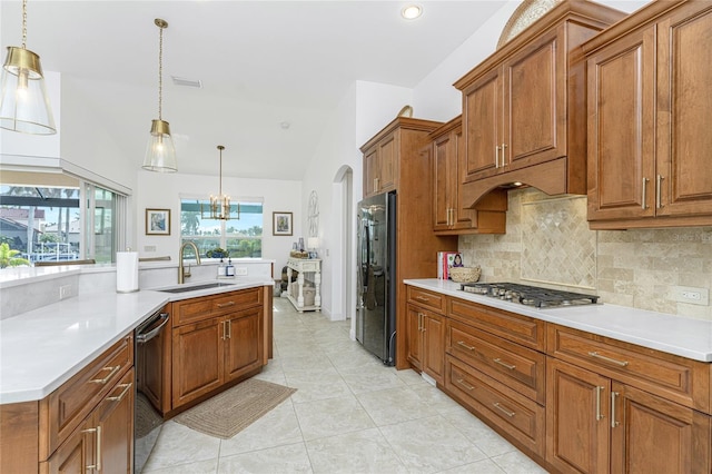 kitchen featuring sink, an inviting chandelier, black appliances, backsplash, and pendant lighting