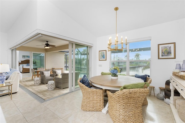 dining space with ceiling fan with notable chandelier, vaulted ceiling, plenty of natural light, and a water view