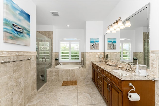 bathroom with tile walls, a wealth of natural light, and plus walk in shower