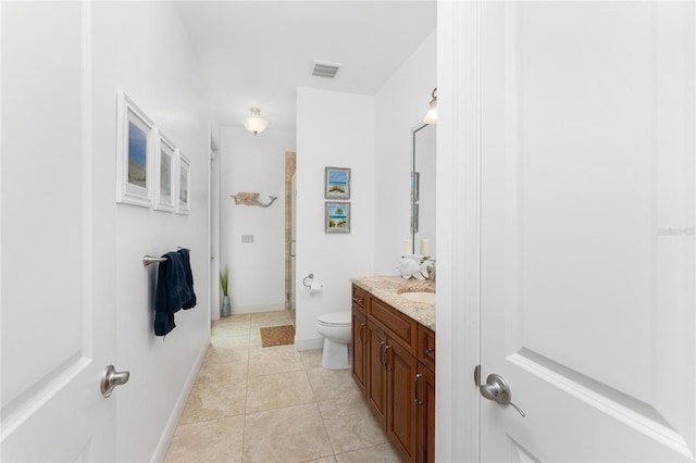 bathroom featuring toilet, a shower with door, tile patterned floors, and vanity