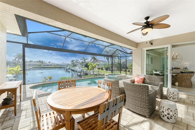 sunroom / solarium featuring ceiling fan, a pool, and a water view