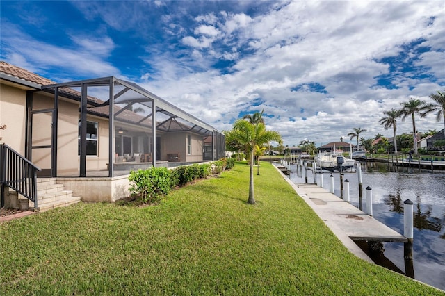 view of yard featuring a lanai, a boat dock, and a water view