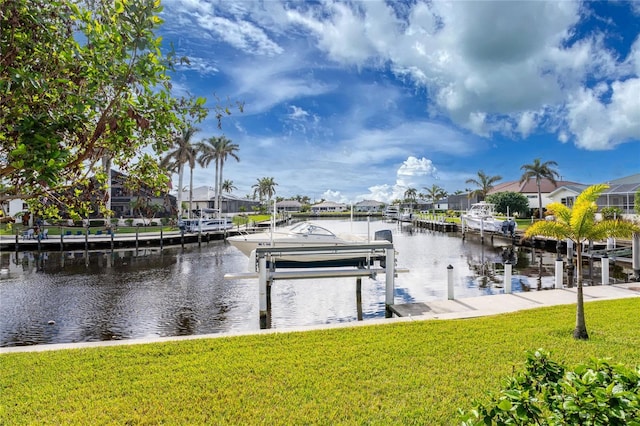 dock area with a lawn and a water view