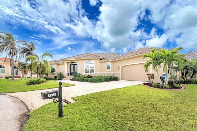 mediterranean / spanish-style home with a front yard and a garage