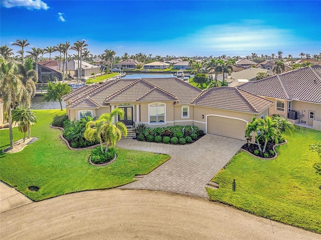 mediterranean / spanish home with a front lawn and a garage