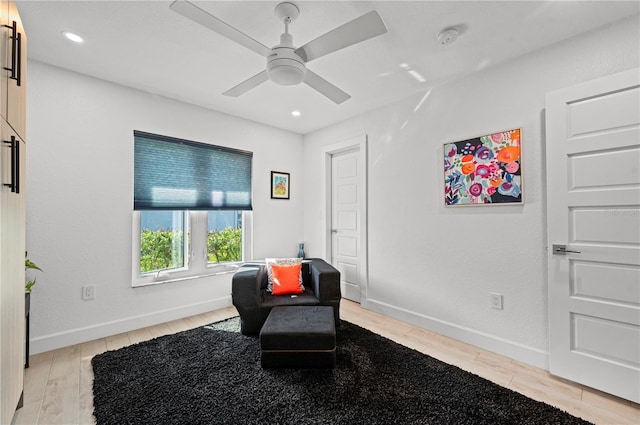 living area with ceiling fan and light hardwood / wood-style flooring