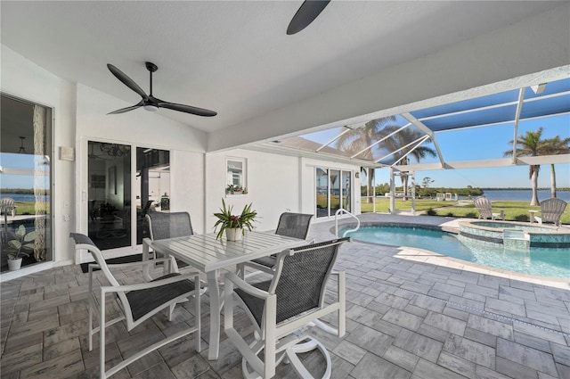 view of swimming pool featuring ceiling fan, a patio area, an in ground hot tub, glass enclosure, and a water view