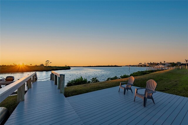 view of dock featuring a lawn and a water view