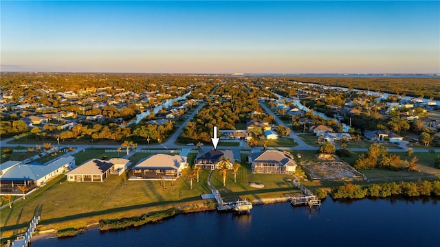 aerial view at dusk featuring a water view