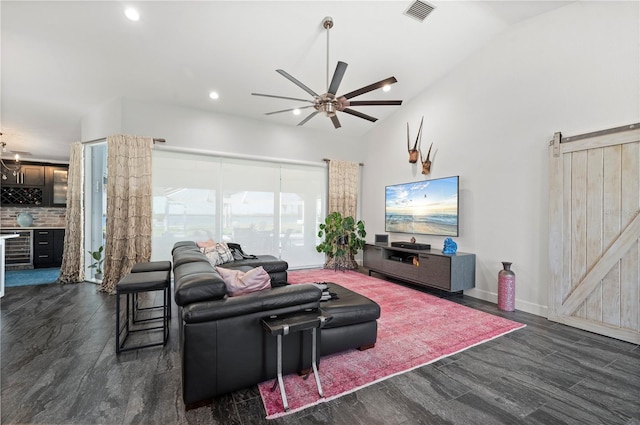 living room with lofted ceiling, a barn door, ceiling fan, indoor bar, and dark wood-type flooring