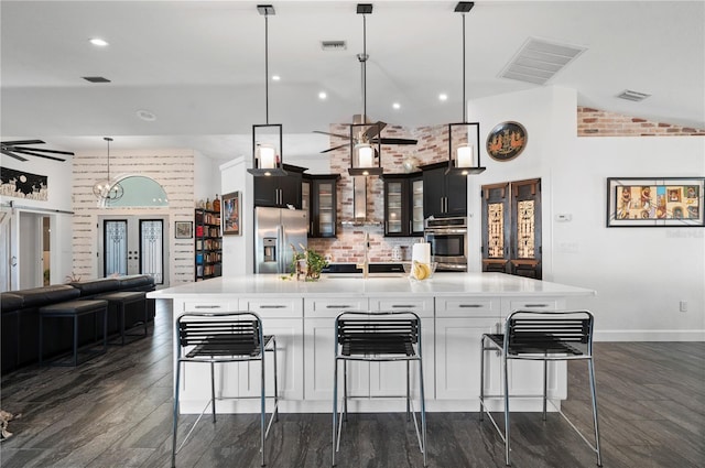 kitchen with decorative light fixtures, french doors, a large island, and stainless steel appliances