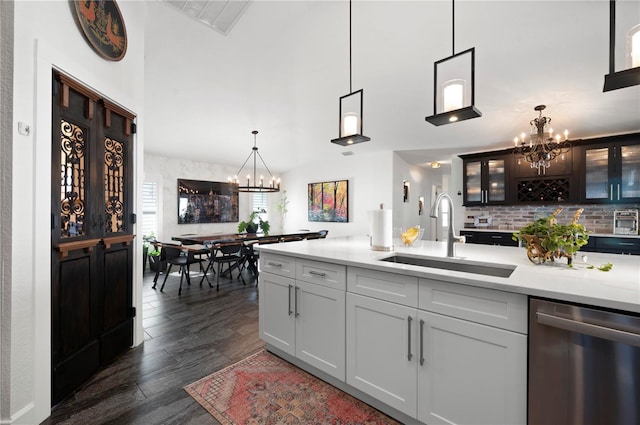 kitchen featuring decorative light fixtures, dark hardwood / wood-style flooring, an inviting chandelier, sink, and stainless steel dishwasher