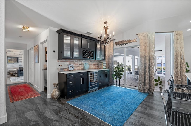 bar featuring an inviting chandelier, pendant lighting, and beverage cooler