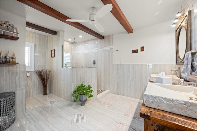 bathroom with ceiling fan, vanity, tile walls, beam ceiling, and a tile shower