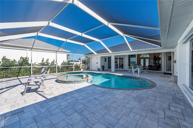 view of swimming pool featuring glass enclosure, an in ground hot tub, and a patio