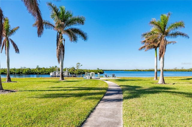 view of home's community with a water view and a lawn