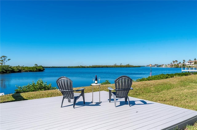 deck with a water view and a yard