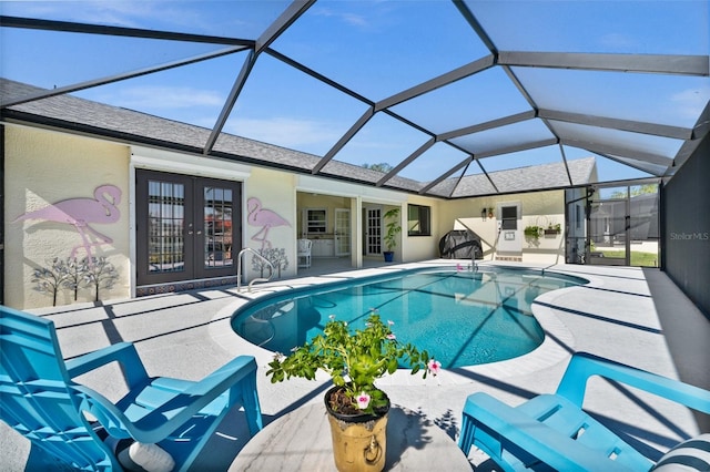 outdoor pool with glass enclosure, french doors, and a patio