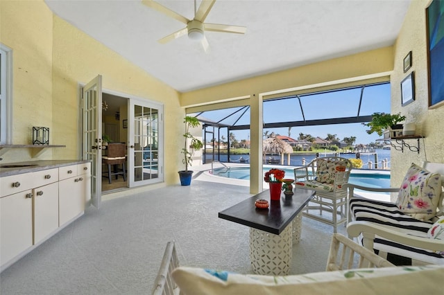 sunroom with ceiling fan, vaulted ceiling, a water view, and a sink