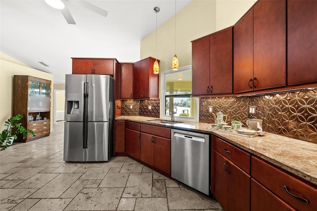 kitchen with stone tile floors, a sink, appliances with stainless steel finishes, decorative backsplash, and decorative light fixtures