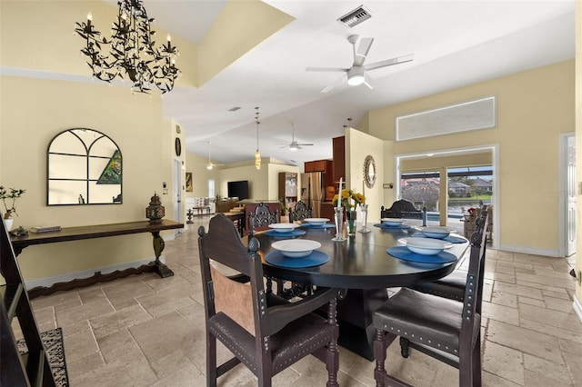 dining area featuring high vaulted ceiling, ceiling fan with notable chandelier, visible vents, baseboards, and stone tile flooring