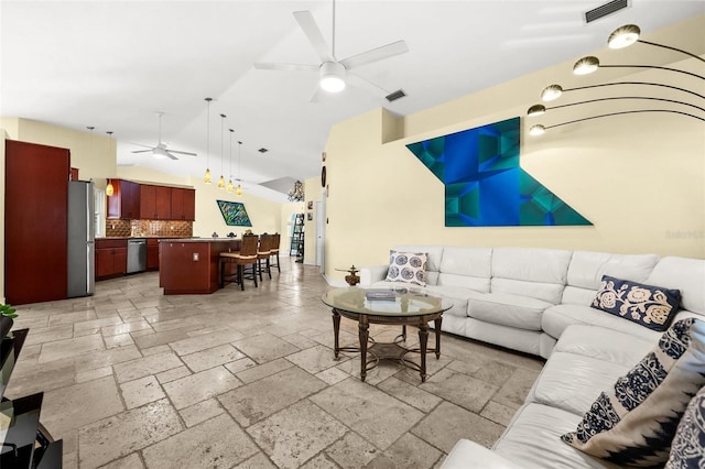 living area with a ceiling fan, visible vents, vaulted ceiling, and stone tile flooring