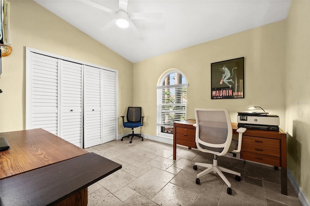 home office featuring baseboards, vaulted ceiling, stone tile floors, and ceiling fan