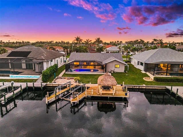 rear view of property featuring an outdoor pool, a patio, boat lift, a water view, and a gazebo