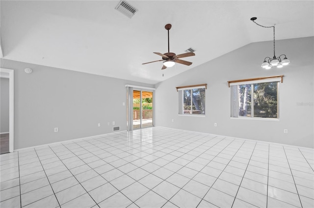 tiled spare room featuring ceiling fan with notable chandelier and lofted ceiling