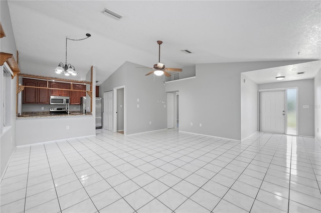 unfurnished living room featuring a textured ceiling, light tile patterned floors, lofted ceiling, and ceiling fan with notable chandelier