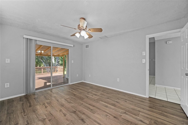 spare room featuring ceiling fan, a textured ceiling, and dark hardwood / wood-style floors