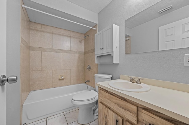 full bathroom featuring toilet, vanity, tiled shower / bath, and tile patterned flooring