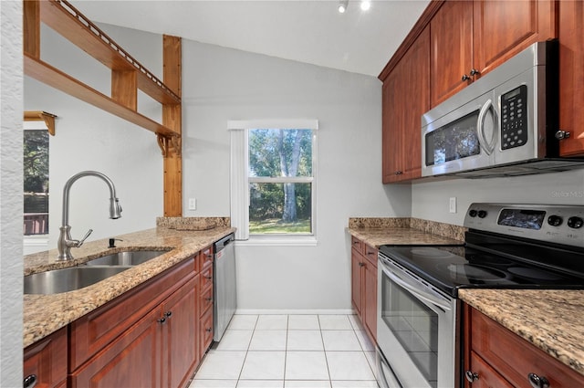 kitchen featuring light tile patterned floors, appliances with stainless steel finishes, lofted ceiling, light stone countertops, and sink