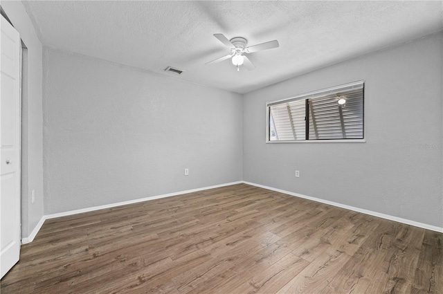 spare room with ceiling fan, wood-type flooring, and a textured ceiling