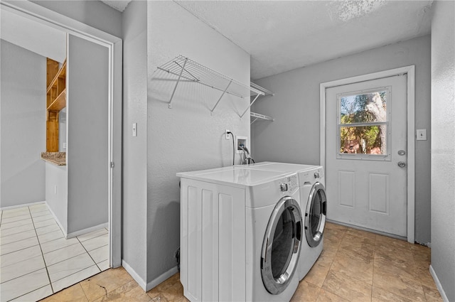 washroom featuring washer and clothes dryer and light tile patterned floors