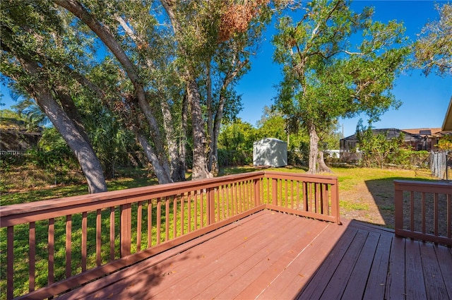 deck featuring a lawn and a storage unit