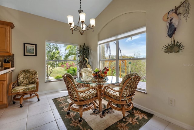 dining space with light tile patterned floors, vaulted ceiling, and an inviting chandelier