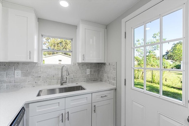 kitchen featuring decorative backsplash, white cabinetry, and sink