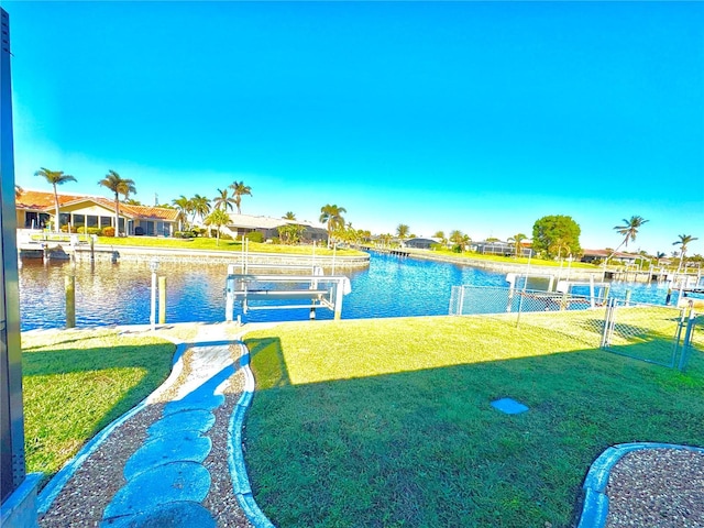 dock area with a lawn and a water view