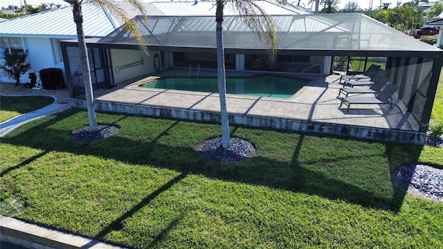 view of swimming pool featuring a lanai, a yard, and a patio