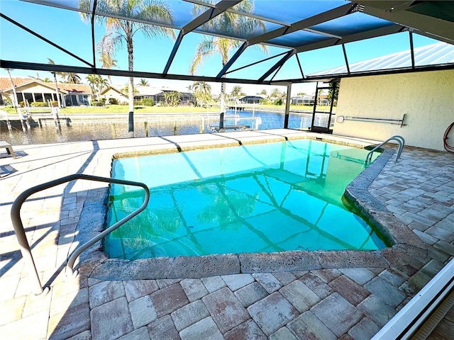 view of swimming pool featuring glass enclosure, a patio area, a water view, and a dock