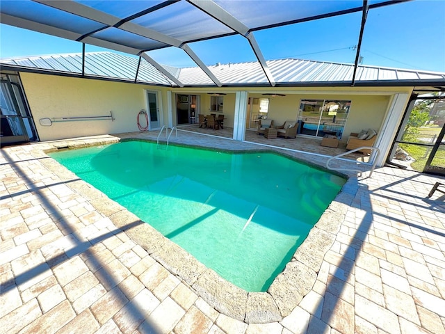 view of pool featuring a lanai, outdoor lounge area, ceiling fan, and a patio