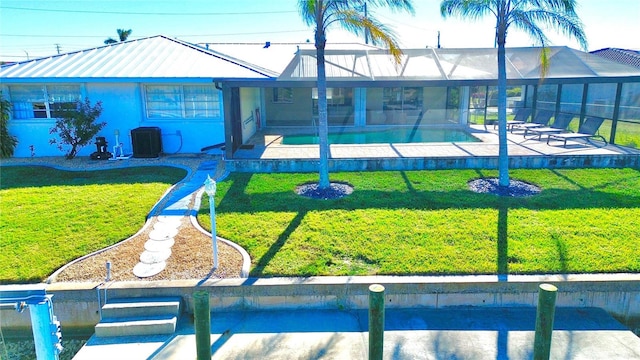 exterior space with a front lawn, central air condition unit, glass enclosure, a patio, and a fenced in pool