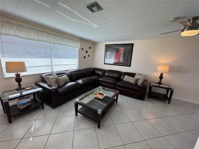 tiled living room with ceiling fan and a textured ceiling