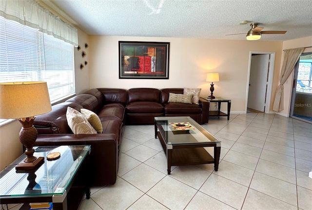 tiled living room featuring a textured ceiling, plenty of natural light, and ceiling fan