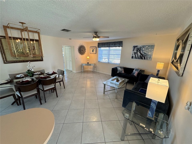 living room featuring a textured ceiling, tile patterned floors, and ceiling fan