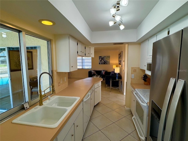 kitchen featuring sink, white cabinets, and white appliances