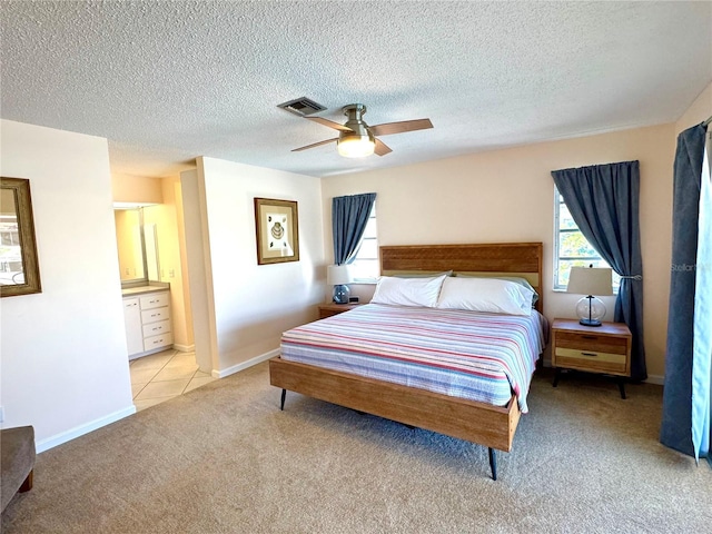 carpeted bedroom featuring ceiling fan, a textured ceiling, and ensuite bath