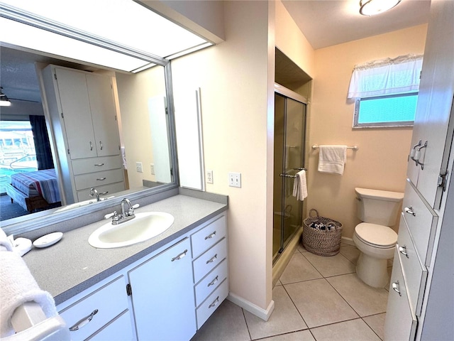 bathroom with toilet, vanity, tile patterned floors, and a healthy amount of sunlight