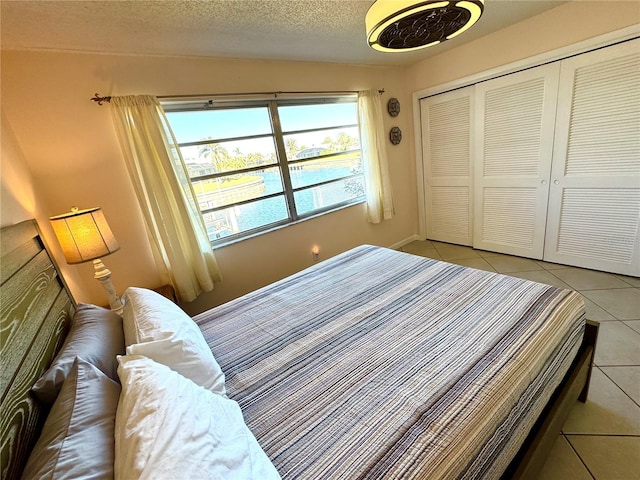 tiled bedroom featuring a closet and a textured ceiling